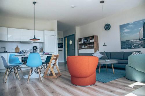 a kitchen and a living room with a table and chairs at Villa Dünengras, 4GW16A in Heiligenhafen