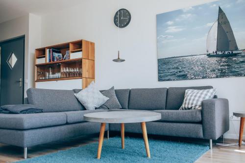 a living room with a couch and a sailboat on the wall at Villa Dünengras, 4GW16A in Heiligenhafen