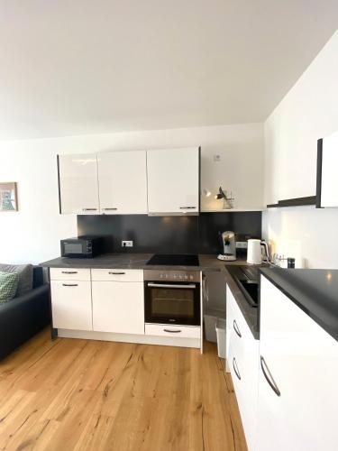 a kitchen with white cabinets and a wooden floor at Pastelani in Buckow