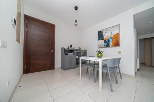 a kitchen with a table and chairs and a wooden door at Central Luxurious 2 bedroom flat in Strovolos