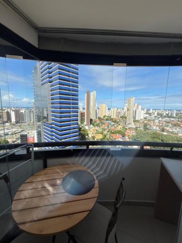 a room with a wooden table and a large window at Mercure Boulevard Salvador Hotel 20 Andar in Salvador