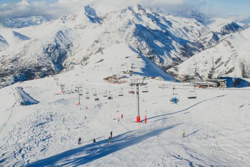 a group of people on a ski lift on a snow covered mountain at Résidence Brinbelles by Leavetown Vacations in Les Deux Alpes