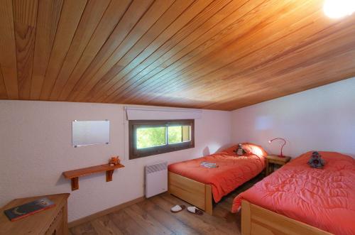 a bedroom with two beds and a wooden ceiling at Résidence Brinbelles by Leavetown Vacations in Les Deux Alpes