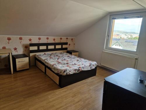 a bedroom with a bed and a large window at Gruia Ele Apartament in Cluj-Napoca