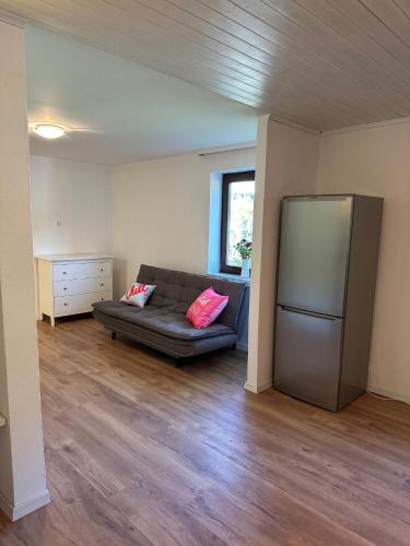 a living room with a couch and a refrigerator at Ferienwohnung Seestern-Mondsee in Unterach am Attersee