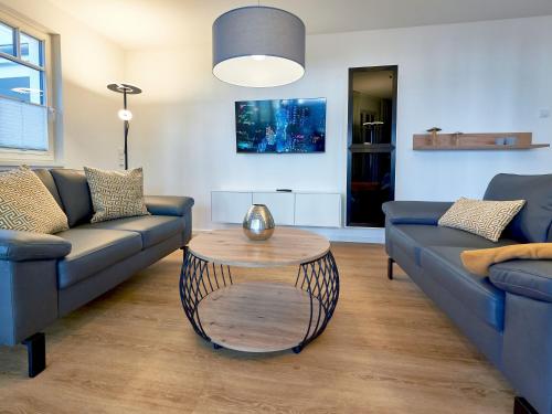 a living room with two couches and a coffee table at Villa Beatrice - Wohnung 01 in Binz