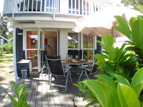 a patio with a table and chairs and an umbrella at Ferienhaus Sonnenblume in Baabe in Baabe