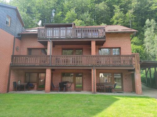 a large brick house with a deck on top of it at Gästehaus Harzklause 7 in Sieber