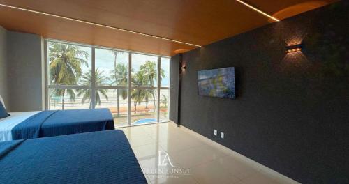 a bedroom with two beds and a large window at LA Green Sunset in João Pessoa