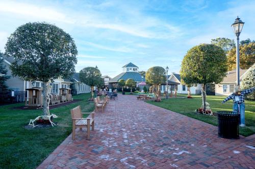 a brick path in a park with benches and houses at Soundview Beach House: 4BR,Panoramic Views 1.5hrsNYC in Wading River