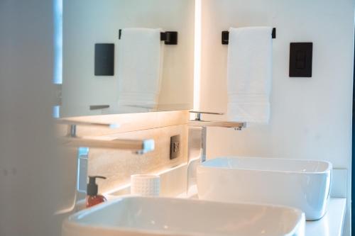 a bathroom with a sink and two rolls of paper towels at Epic Tamarindo Boutique Hotel in Tamarindo