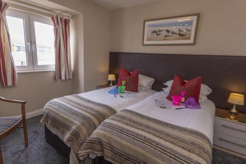 a hotel room with two beds with stuffed animals on them at The Beachcroft Hotel, BW Signature Collection in Bognor Regis