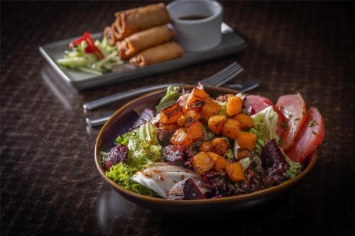 a bowl of salad on a table with a plate of food at Best Western Ship Hotel in Weybridge