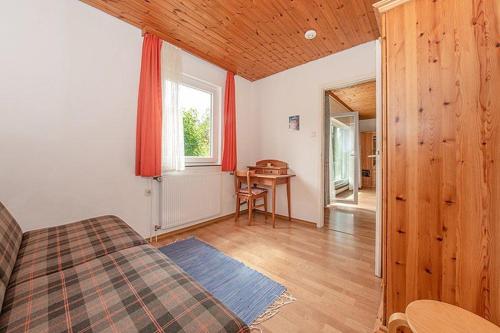 a bedroom with a bed and a table in a room at Ferienhäuser im Feriendorf Weissensee im Allgäu F2 in Füssen