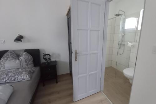 a bathroom with a bed and a shower and a toilet at Éden Garten Vendégház in Magyarpolány