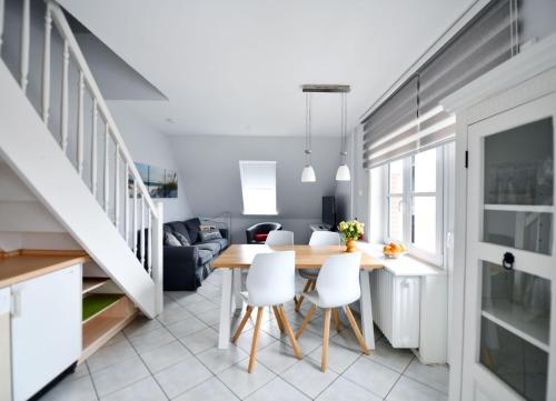 Una cocina y un comedor con mesa y sillas. en Haus Windhuug Wohnung 5, en Utersum