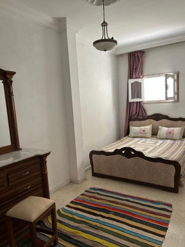 1 dormitorio con 1 cama, 1 silla y 1 alfombra en Dar Nawara, en Kelibia