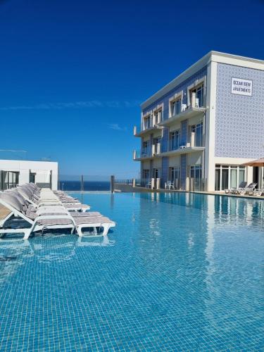 a swimming pool in front of a building at Ocean View Apartments in Lourinhã