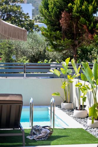 a swimming pool with plants on the grass next to it at Adell Oasis in Iraklitsa