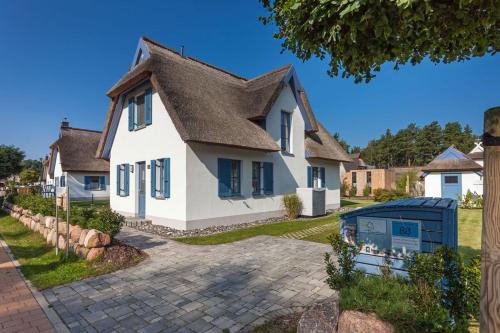a white house with a brown roof at Dünenbraut in Glowe