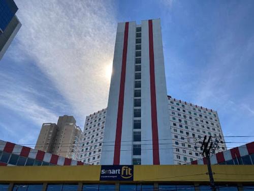 a tall building with a red stripe on it at Lindo estúdio frente à praia in Santos