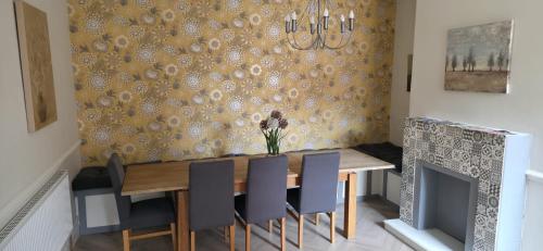 ein Esszimmer mit Tisch und Stühlen und einem Kamin in der Unterkunft Stunning Spacious Home Close to Blackpool Beach in Blackpool
