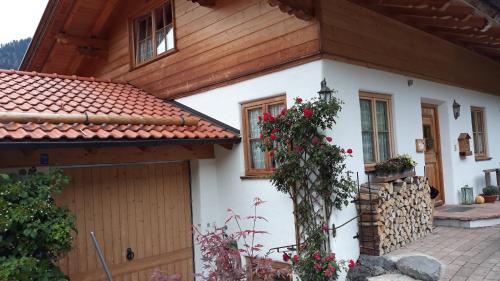 a white house with a red roof at Landhaus am Bergfeld in Bayrischzell