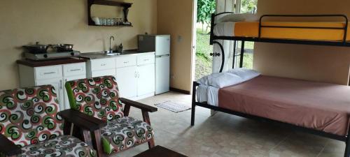 a room with two bunk beds and a kitchen at Essence Arenal Spa & Yoga in El Castillo de La Fortuna