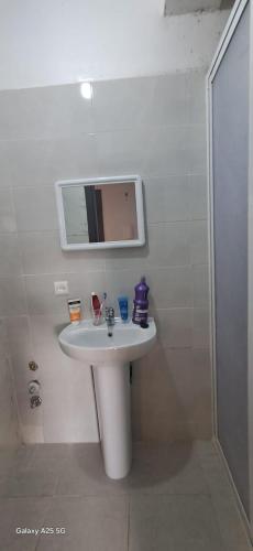 a bathroom with a white sink and a mirror at Golf msnana in Tangier