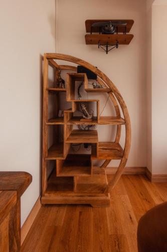 a wooden book shelf in a corner of a room at Luxury Cottage by Fairy Pools 4 in Carbost