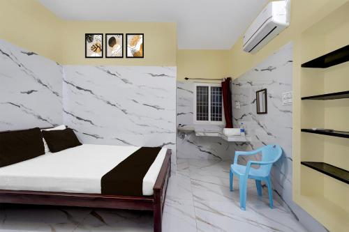 RanipetHotel O RR Residency的一间卧室，有一张床和一把蓝色椅子
