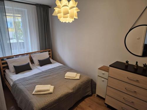 a bedroom with a bed with two towels on it at Justinrent Rynek 36 in Legnica