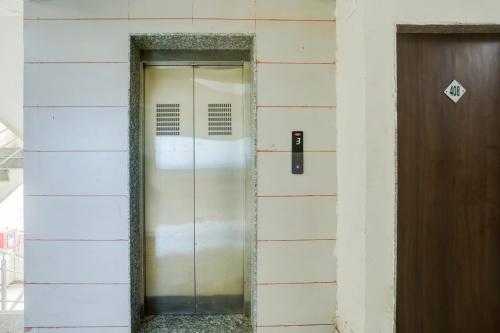 a glass door in a building next to a wooden door at Hotel O Happy Stay Asalali in Ahmedabad