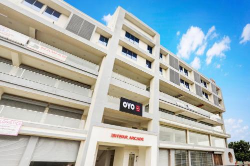 a white building with a sign in front of it at Hotel O Happy Stay Asalali in Ahmedabad