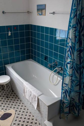 a bathroom with a tub and a blue tiled wall at Ferienwohnung Monteurwohnung in Ankum