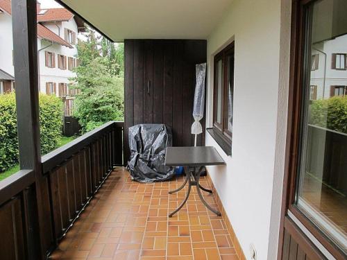 a balcony with a table and a chair on a porch at Ferienwohnung Promenadenweg Nesselwang 10-2 in Nesselwang