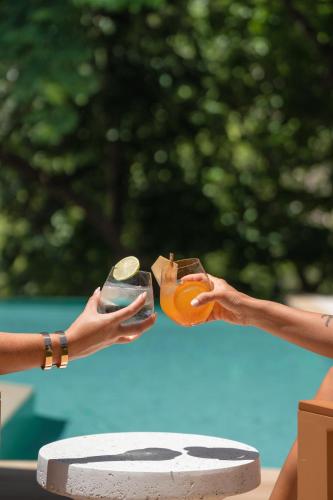 two people holding up a camera in their hands at Epic Tamarindo Boutique Hotel in Tamarindo
