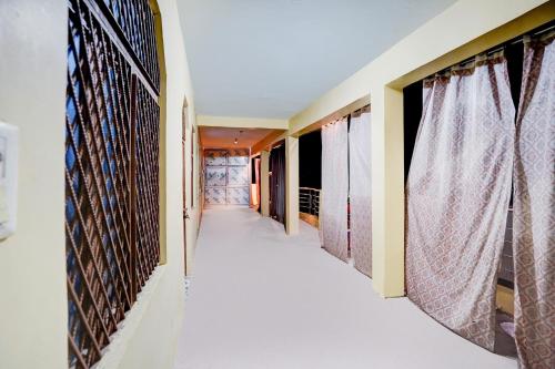 a corridor of a house with windows and curtains at SPOT ON Parihar Hotel in Binaur