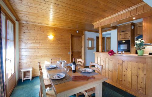 ein hölzernes Esszimmer mit einem Tisch und einer Küche in der Unterkunft Résidence Alpina Lodge by Leavetown Vacations in Les Deux Alpes