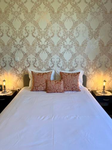 a bedroom with a white bed with two tables and two lamps at Thomar House in Tomar