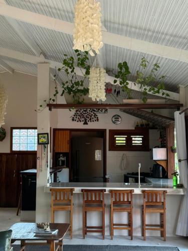 a kitchen with a counter with chairs and a table at BEACH HOUSE Tatajuba in Camocim