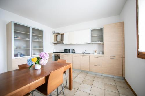a kitchen with a wooden table with flowers on it at Oasi di pace nel sito UNESCO del Prosecco DOCG in Farra di Soligo
