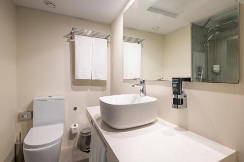 a white bathroom with a sink and a toilet at Leonardo Royal Hotel Mallorca in Palmanova