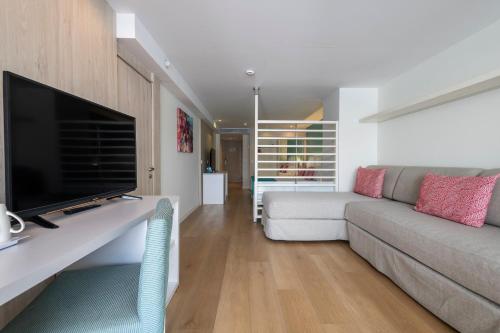 a living room with a couch and a flat screen tv at Leonardo Royal Hotel Mallorca in Palmanova