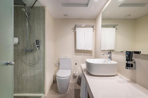 a bathroom with a toilet and a sink and a shower at Leonardo Royal Hotel Mallorca in Palmanova