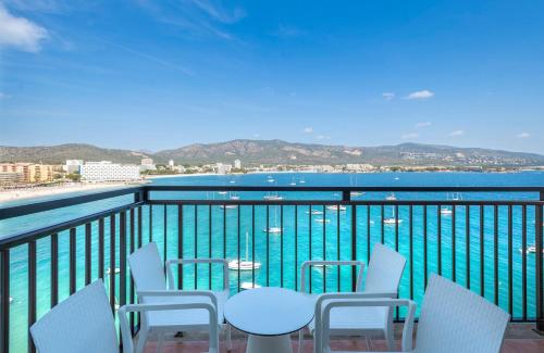 a balcony with chairs and a table and the water at Leonardo Royal Hotel Mallorca in Palmanova