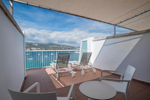 a balcony with chairs and tables and a view of the water at Leonardo Royal Hotel Mallorca in Palmanova