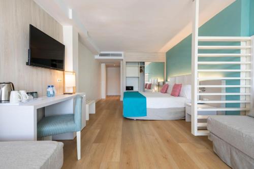 a bedroom with a bed and a desk in a room at Leonardo Royal Hotel Mallorca in Palmanova