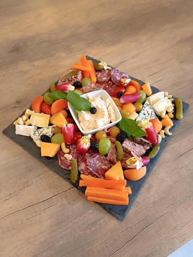 a plate of vegetables and cheese on a table at Micro Maison indépendante in Commelle-Vernay