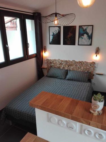 a small bedroom with a bed and a table at Micro Maison indépendante in Commelle-Vernay